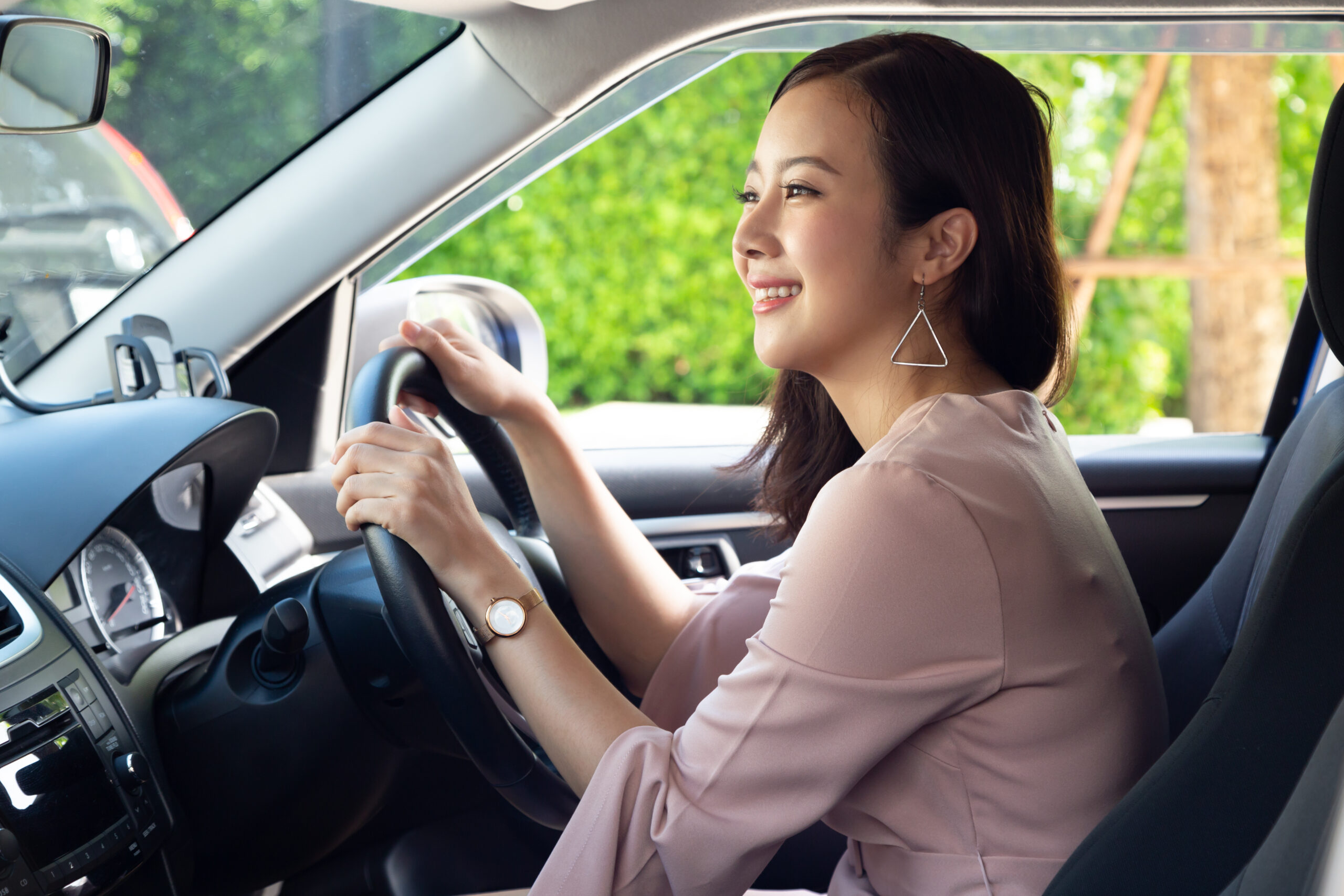 Driver Asian woman smiling and sitting inside car while traffic jam on the road
